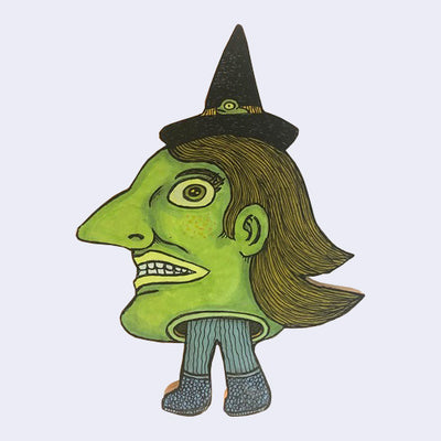 Die cut wooden sculpture of a large witch head, green with a strong nose and a black hat atop. A pair of small legs come out the bottom of the head.