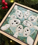 Ceramic tile, teal blue with a light blue circle, and 8 small white ghost like figures circling around the exterior, Kodama characters from Princess Mononoke.