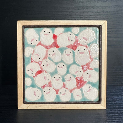 Ceramic tile, light blue with a light red circle. The foreground is full of white cloud like characters, Warawara from The Boy and the Heron.