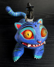 Colorful cat-like creature with large eyes and a small bird figure on its back against a dark background