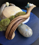 Ceramic sculpture of Totoro, positioned on a tree branch and playing a small wind instrument. Next to him are tiny Chibi Totoro, also playing instruments. Background is a circular blue sky with a giant moon.