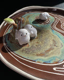 Ceramic dish with decorative elements on a dark surface