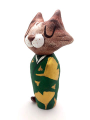 Sculpture of a large headed cartoon cat, wearing a green kimono with gold gingko leaves over it. Its eyes are closed and it has a content expression on its face.