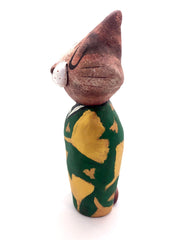 Sculpture of a large headed cartoon cat, wearing a green kimono with gold gingko leaves over it. Its eyes are closed and it has a content expression on its face.