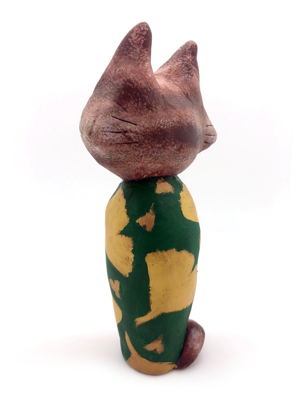 Sculpture of a large headed cartoon cat, wearing a green kimono with gold gingko leaves over it. Its eyes are closed and it has a content expression on its face.