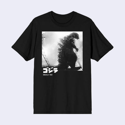 Black tee shirt with a large greyscale square photo of Godzilla's silhouette, walking past power lines. Below, there is text in Japanese and English.