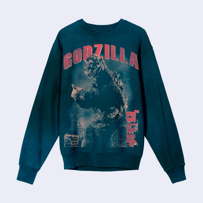 Teal blue sweatshirt with a vintage graphic of Godzilla, standing tall and holding a small plane in his hands amongst a busy city. Red text atop reads "Godzilla."