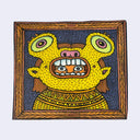 Illustration made with many lines, giving it the feel of a folk art woodcut on a rectangular wood panel of a person seen only from the shoulders up wearing a golden goblin suit, with the mask only showing their eyes through an opening in the goblin's mouth.