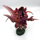 Sculpture of a lobster kaiju monster on a stand against a white background, as thought it is being barbecue skewer.