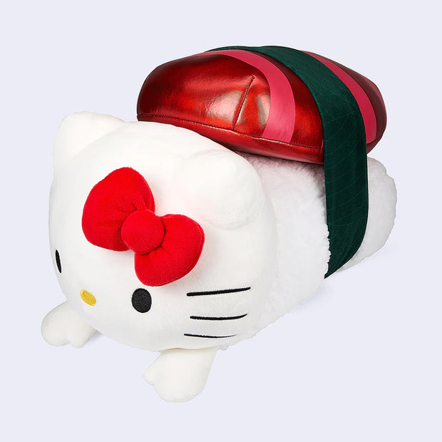 Plush doll of Hello Kitty as a piece of sushi, with bright red metallic mini pillow on top of her body which is shaped like rice. A strip of seaweed goes around it.
