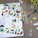 Sheet of decorative stickers with people, trees, and objects on a textured surface.