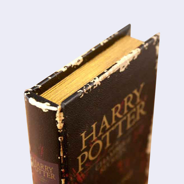 Corner of a hardcover book, dark brown and vintage looking.