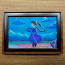 A framed artwork depicting a stylized figure in a blue robe under a starry night sky, floating over a drawn hopscotch on the ground.