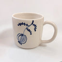 White mug with blue floral design on a white background
