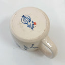 White ceramic mug with blue floral design on a white background