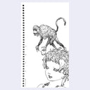 Notebook with a black and white illustration of a monkey on a woman's head.
