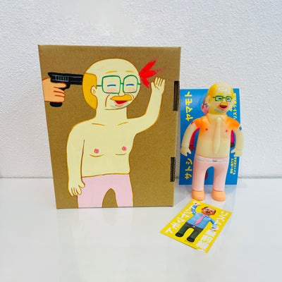 Semi translucent soft vinyl figure of a business man, shirtless in light pink slacks. He stands next to a painted box.