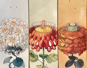 3 skateboard decks with floral themed illustrations.