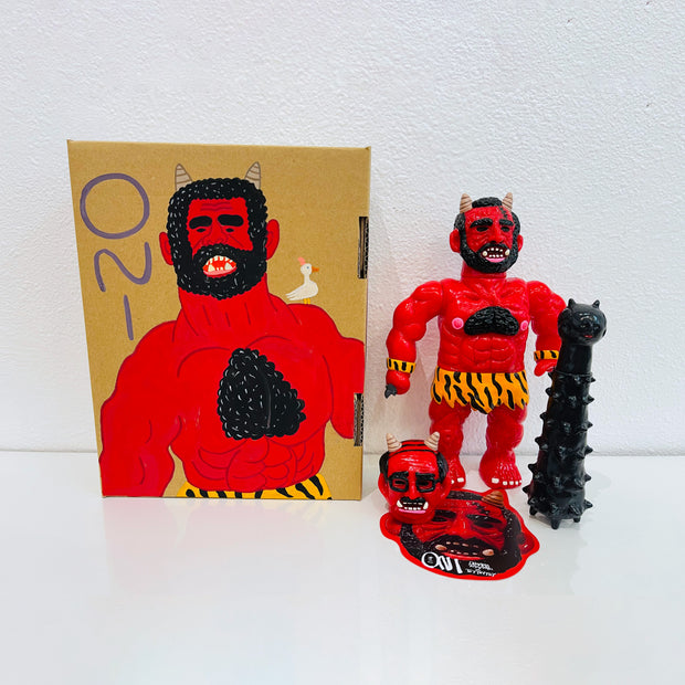 Red soft vinyl figure of a demon man, with muscles and horns atop his head. He has a large black spiked club and a human head at his feet. He stands next to a painted box.