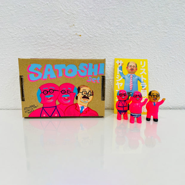Set of 3 small vinyl neon pink figures of little business men. One wears a suit, another wears a red bondage wear and the last wears striped underwear. They stand next to a painted box.