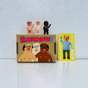 Set of 3 small vinyl figures of little business men. They are all nude and are of differing skin tones. They stand next to a painted box.