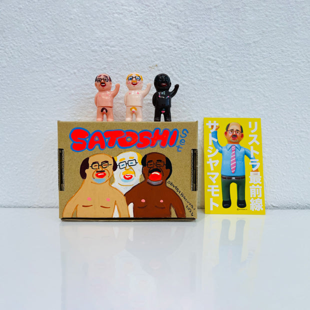 Set of 3 small vinyl figures of little business men. They are all nude and are of differing skin tones. They stand next to a painted box.