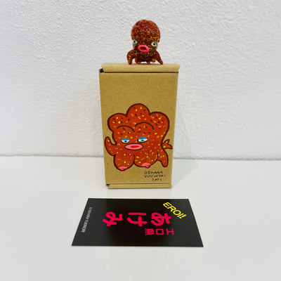 Small brown soft vinyl figure of an octopus creature, with a large head and small limbs. It stands on a painted box.