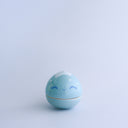 Small blue round bottomed jar with a lid. The lid has a slightly pointed tip wit white coloring and a drawn on, cute face. 