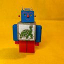 Colorful wooden robot toy with a turtle design on a yellow background