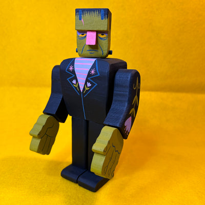 Assembled wooden sculpture of a Frankenstein character, with moving arms and subtle floral patternings.