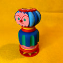 Colorful wooden toy with a face on a yellow background