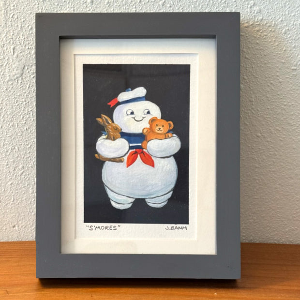 Framed painting of the Stay Puft Marshmallow Man holding a chocolate bunny in one arm and a Teddy Graham in the other. 