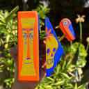 Wooden assemblage sculpture of a tiki bar sign with a tiki skull and a small bird.