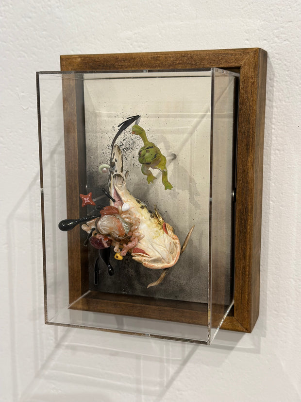 Mixed media diorama scene of a small green frog slaying a large monstrous fish with a knife, splaying the fish's guts over the scene.