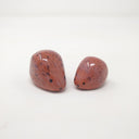 2 small, simplistic rounded sculptures of brown hedgehogs.