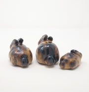  3 small ceramic bunnies, glazed to look like they are toasted marshmallows. They are sized medium, large and smallest.