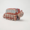Ceramic sculpture of the Catbus from My Neighbor Totoro with muted colorings and a simplistic drawn on face.
