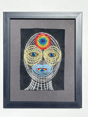 Framed artwork of colorful concentric circles portrait of a head on a black background