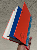 Journal held in someone's hand, showing the back cover and some of the white, blank pages.