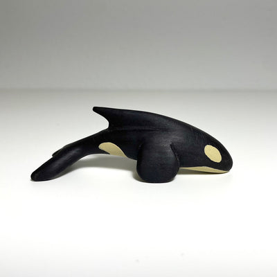 Carved and painted wooden sculpture of an orca whale.