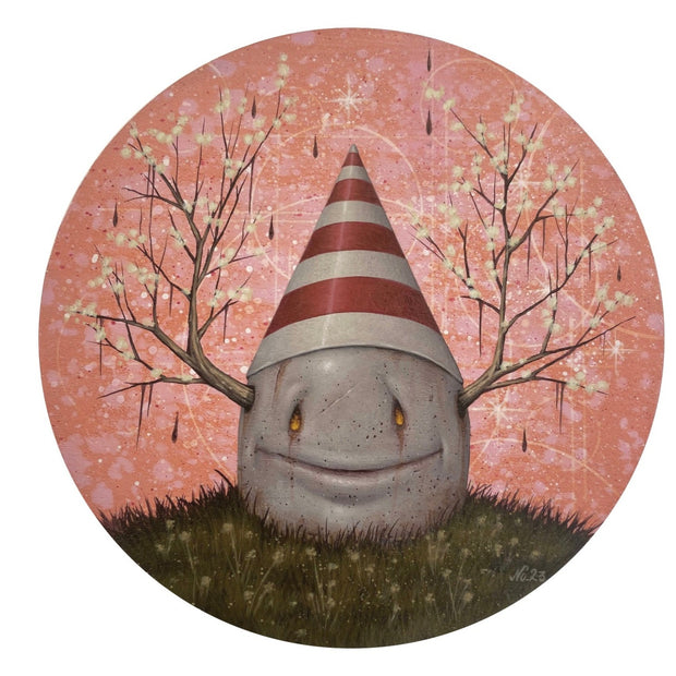 Painting on circular panel of a weathered egg, half buried into the ground. It has white flowered branches coming out its side like antlers, a striped white and red cone hat and tiny glowing orange eyes and wide closed mouth grin.