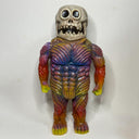 Colorful creature figure with a skeleton head on a white background