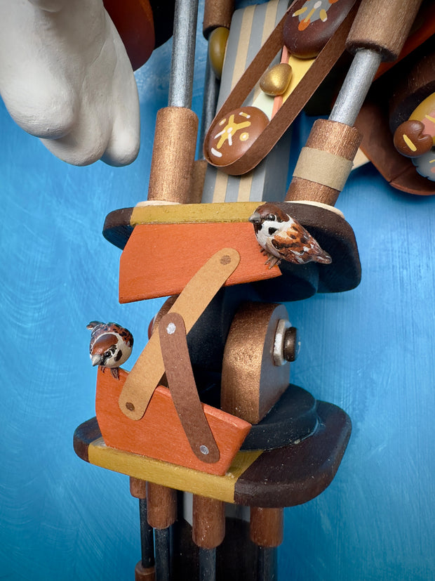 Very intricate sculpture of a robot made out of small wooden parts, resembling a cat or a dog. It is being piloted by small characters with smaller animals all over the robot.]