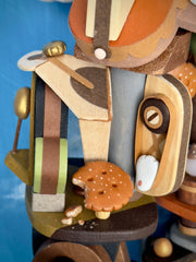 Very intricate sculpture of a robot made out of small wooden parts, resembling a cat or a dog. It is being piloted by small characters with smaller animals all over the robot.