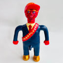 Toy figure with red cap and sash on a white background