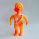 Orange plastic figure with a sash on a gray background