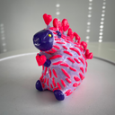 Colorful toy figure on a white surface with a light gray background