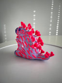 Colorful plastic toy resembling a hedgehog on a white surface with a light gray background