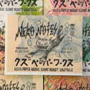 Memo pad with a sharp toothed cartoon cat on the cover, lunging forward. It is positioned atop a stack of similar notebooks with different colored covers but same illustration.