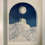  Delicate paper cutting made out of blue dyed paper of a woman's nude body sitting atop of a mountain range. She has no head and is turned away so only her back and butt are showing. A full moon is in the night sky.